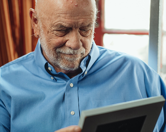 gentleman looking at a photo frame