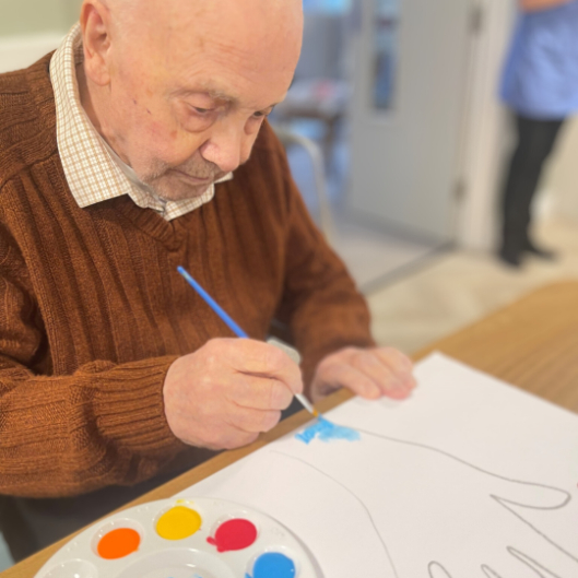 Gentleman in brown jumper painting