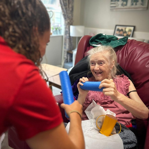 Lady sitting in red chair enjoying some chair exercise