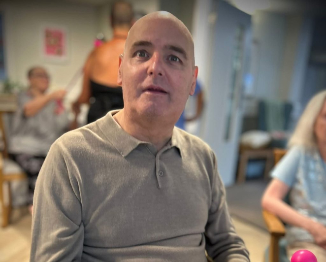 man in a grey t--shirt looking at the camera