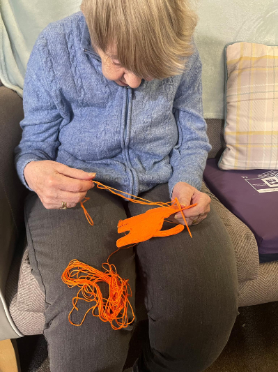 lady stitching with orange thread