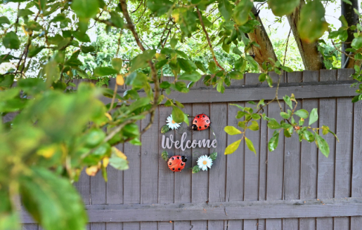 Welcome sign on a grey fence