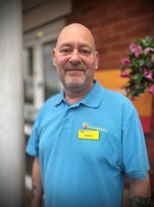 man in blue polo shirt standing outside care home