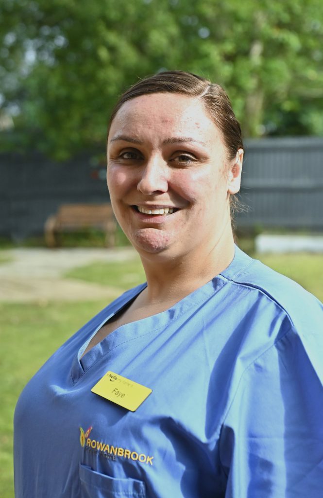 woman in blue nurses uniform smiling outdoors